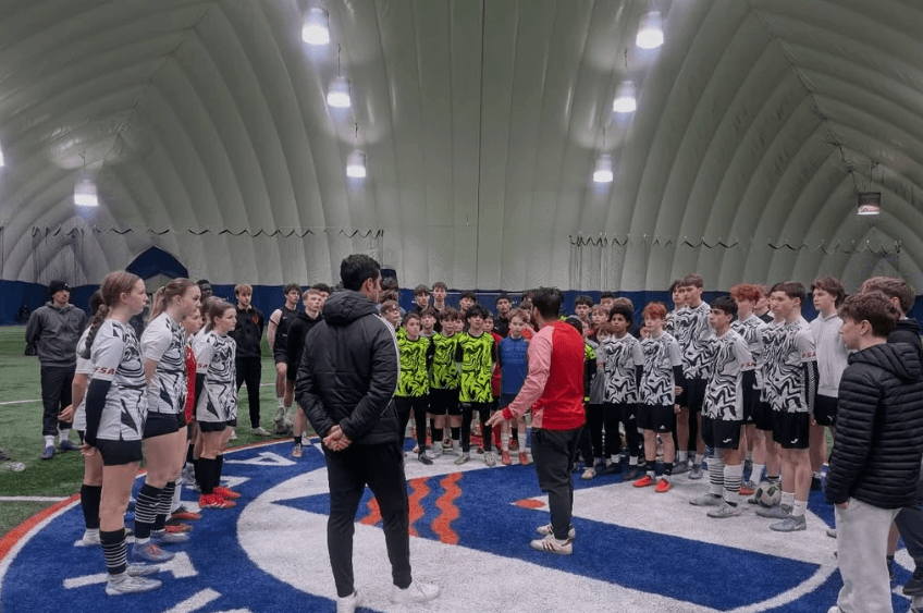 Coaches addressing the FSA youth squads in the indoor dome