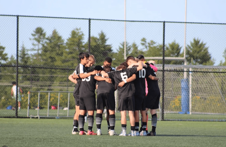 FSA squad in a pre-match huddle on the pitch